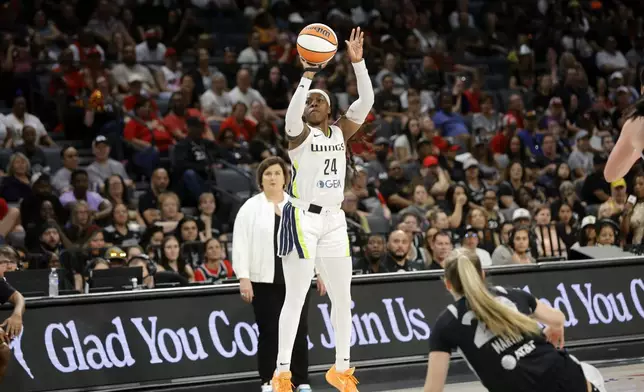 Dallas Wings guard Arike Ogunbowale (24) takes a three-point shot as Las Vegas Aces guard Kate Martin, right, alls during the first half of a WNBA basketball game Sunday, July 7, 2024, in Las Vegas. (Steve Marcus/Las Vegas Sun via AP)