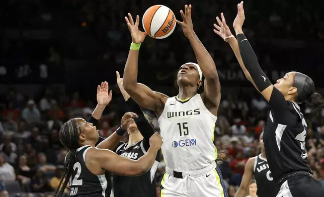 Dallas Wings center Teaira McCowan (15) grabs a rebound between Las Vegas Aces guard Chelsea Gray, left and center A'ja Wilson during the first half of an WNBA basketball game, Sunday, July 7, 2024, in Las Vegas. (Steve Marcus/Las Vegas Sun via AP)