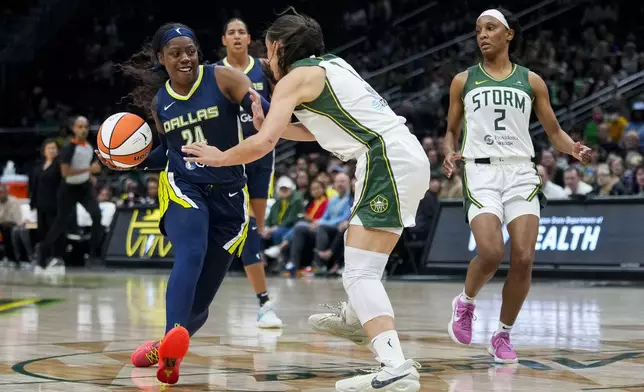 Dallas Wings guard Arike Ogunbowale (24) drives the ball against Seattle Storm guard Nika Muhl during the second half of a WNBA basketball game, Monday, July 1, 2024, in Seattle. The Storm won 95-71. (AP Photo/Lindsey Wasson)