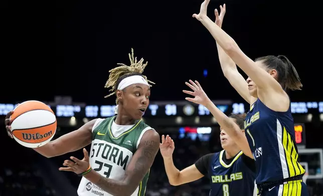 Seattle Storm guard Jordan Horston, left, looks to drive the ball around Dallas Wings guard Lou Lopez Senechal (8) and guard Sevgi Uzun (1) during the first half of a WNBA basketball game, Monday, July 1, 2024, in Seattle. (AP Photo/Lindsey Wasson)
