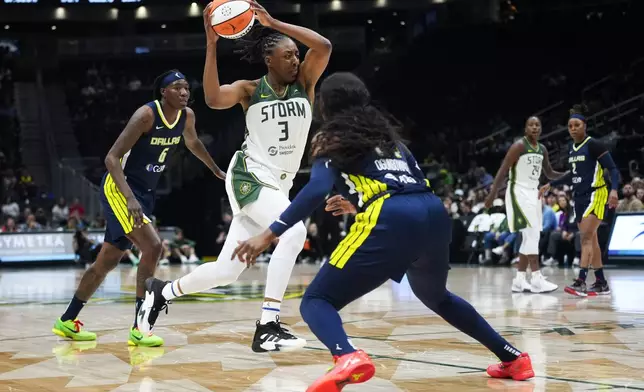 Seattle Storm forward Nneka Ogwumike (3) drives to the basket against Dallas Wings forward Natasha Howard (6) and guard Arike Ogunbowale, right, during the first half of a WNBA basketball game, Monday, July 1, 2024, in Seattle. (AP Photo/Lindsey Wasson)