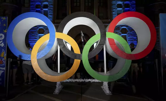 Olympic rings are pictured Wednesday, July 24, 2024, in Salt Lake City, while people gather to watch a live stream from Paris as the International Olympic Committee awards Salt Lake City the 2034 Winter Olympics. (AP Photo/Spenser Heaps)