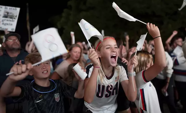 People celebrate while watching a live feed from Paris moments after the International Olympic Committee awarded Salt Lake City the 2034 Winter Olympics, Wednesday, July 24, 2024, in Salt Lake City. (AP Photo/Spenser Heaps)