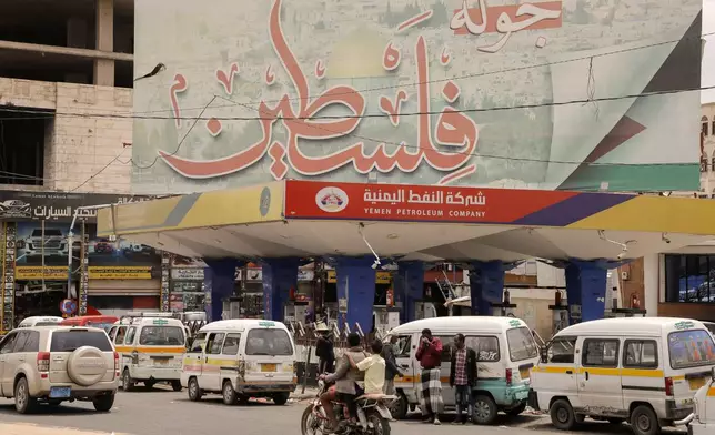 Yemenis drive past a giant billboard supporting Palestinians, in Sanaa, Yemen, Sunday, July 21, 2024. Arabic slogan reads, "it's Palaestine's turn". (AP Photo/Osamah Abdulrahman)