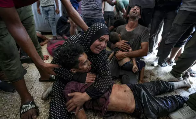 ADDS PALESTINIAN WOMAN'S NAME - Faten Mreish holds her son who was killed in the Israeli bombardment of the Gaza Strip at a hospital morgue in Deir al-Balah, Wednesday, Aug. 28, 2024. (AP Photo/Abdel Kareem Hana)