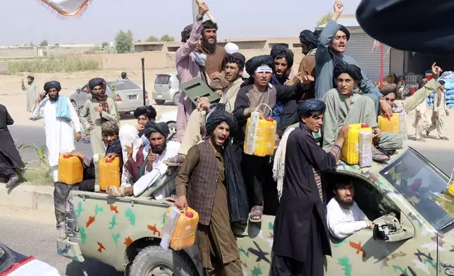 Taliban fighters carry dummy yellow canisters intended to represent homemade explosives, as they celebrate the third anniversary of the withdrawal of US-led troops from Afghanistan, in Lashkar Gah, Helmand province, southwestern Afghanistan, Wednesday, Aug. 14, 2024. (AP Photo/Abdul Khaliq)