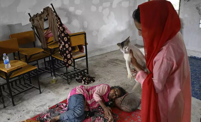 People displaced by floods rest at a relief shelter in Mohipal, Feni, a coastal district in southeast Bangladesh, Friday, Aug. 23, 2024. (AP Photo/Fatima Tuj Johora)