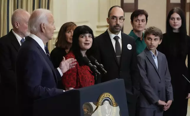 President Joe Biden delivers remarks on a prisoner swap with Russia from the State Dining Room of the White House, Thursday, Aug. 1, 2024, in Washington, as the family of hostage Evan Gershkovich, looks on. (AP Photo/Alex Brandon)