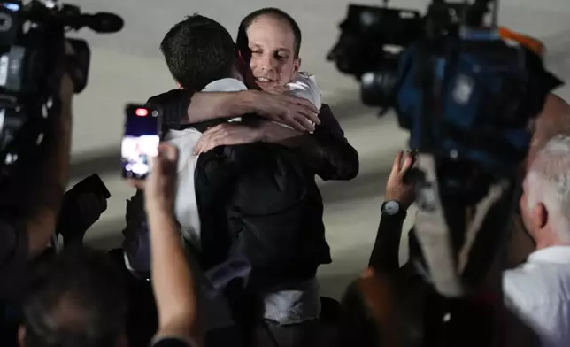 Reporter Evan Gershkovich receives an embrace from a colleague following his release as part of a 24-person prisoner swap between Russia and the United States on Thursday, Aug. 1, 2024. (AP Photo/Manuel Balce Ceneta)