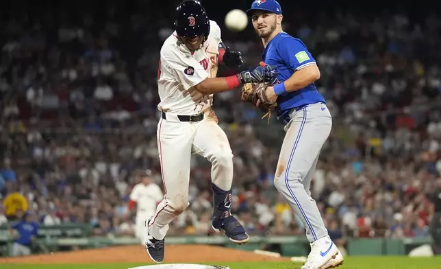 Toronto Blue Jays first baseman Spencer Horwitz, right, watches the ball as Boston Red Sox's Ceddanne Rafaela reaches first on a throwing error by Blue Jay's pitcher Tommy Nance during the sixth inning of a baseball game at Fenway Park, Tuesday, Aug. 27, 2024, in Boston. (AP Photo/Charles Krupa)