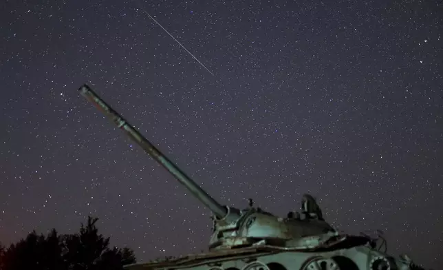 A meteor streaks above a destroyed tank from the 1992-1995 war in Bosnia, during the Perseid meteor shower on Bjelasnica mountain, Bosnia, Tuesday, Aug. 13, 2024. (AP Photo/Armin Durgut)