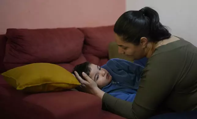 Janaina Silva watches over her four-year-old son Murillo after an epileptic seizure at her parents' home in Guaruja, Brazil, Monday, July 8, 2024. To lessen and shorten his seizures, Murillo takes a steady dose of liquid cannabidiol or CBD, that Silva acquires for free through Sao Paulo state’s public health system. (AP Photo/Andre Penner)