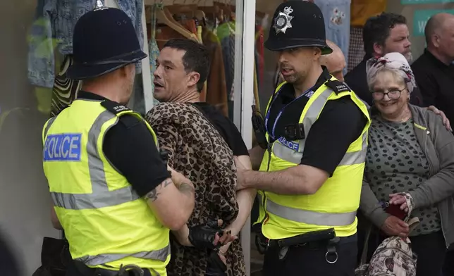 A man is detained by police officers during a protest in Nottingham, England Market Square on Saturday, Aug. 3, 2024, following Monday's stabbing attacks in Southport, in which three young children were killed. (Jacob King/PA via AP)