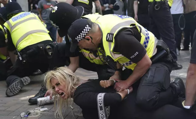 Police officers detain a woman during a protest in Nottingham, England's Market Square Saturday Aug. 3, 2024, following the stabbing attacks on Monday in Southport, in which three young children were killed. (Jacob King/PA via AP)