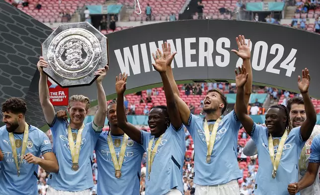 Manchester City midfielder Kevin De Bruyne lifts the trophy after his team won the FA Community Shield soccer match between Manchester City and Manchester United at Wembley Stadium in London, Saturday, Aug. 10, 2024. (AP Photo/David Cliff)