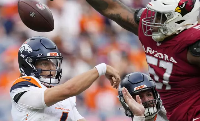 Denver Broncos quarterback Zach Wilson, left, has his pass blocked by Arizona Cardinals defensive end Myles Murphy (57) during the second half of a preseason NFL football game Sunday, Aug. 25, 2024, in Denver. (AP Photo/Jack Dempsey)