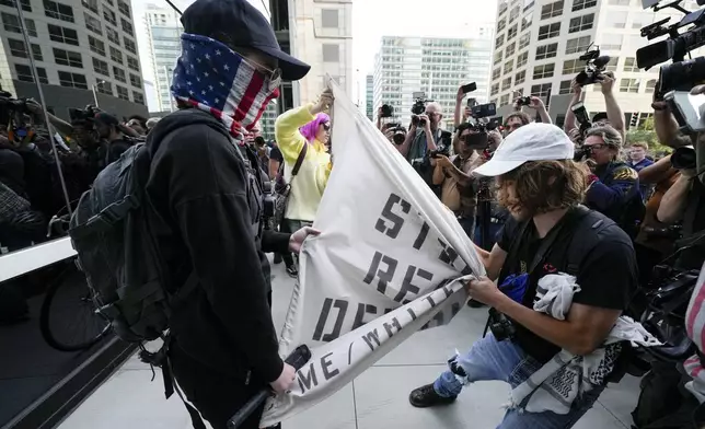 A demonstrator and a counter protester struggle near the Israeli Consulate during the Democratic National Convention Tuesday, Aug. 20, 2024, in Chicago. (AP Photo/Julio Cortez)