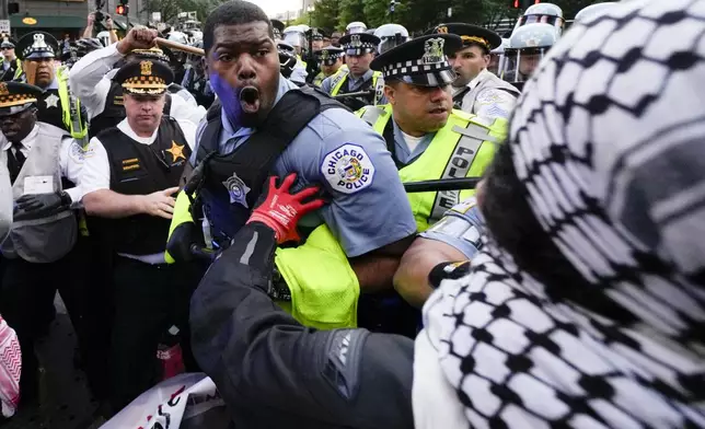 Demonstrators clash with police near the Israeli Consulate during the Democratic National Convention Tuesday, Aug. 20, 2024, in Chicago. (AP Photo/Julio Cortez)