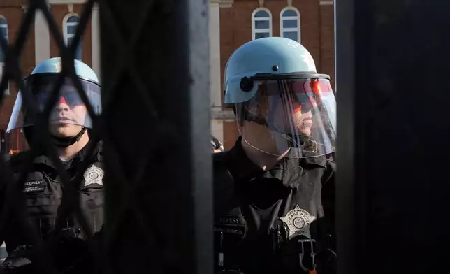 Police stand near where protesters knocked down a fence surrounding United Center at the Democratic National Convention after a march Monday, Aug. 19, 2024, in Chicago. (AP Photo/Frank Franklin II)