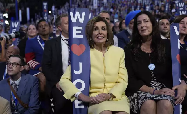 Rep. Nancy Pelosi, D-Calif., holds a sign as President Joe Biden speaks during the Democratic National Convention Monday, Aug. 19, 2024, in Chicago. (AP Photo/Paul Sancya)