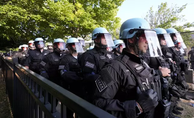 Police line up after a piece of fence was knocked down by protesters surrounding the United Center at the Democratic National Convention Monday, Aug. 19, 2024, in Chicago. (AP Photo/Alex Brandon)