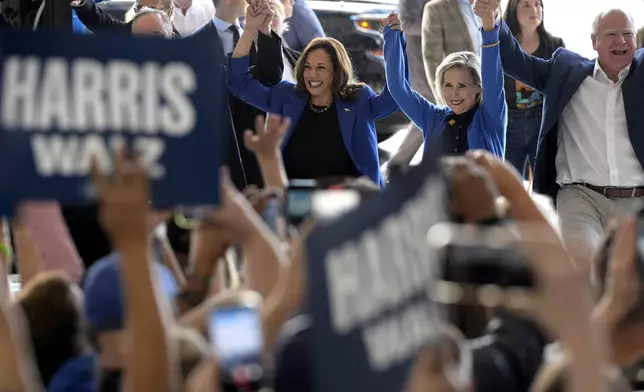 Democratic presidential nominee Vice President Kamala Harris, left, Democratic vice presidential nominee Minnesota Gov. Tim Walz, right, and his wife Gwen Walz arrive at Pittsburgh International Airport, Sunday, Aug. 18, 2024, in Pittsburgh. (AP Photo/Julia Nikhinson)