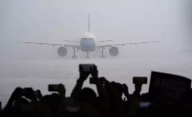 Supporters look on as Air Force Two with Democratic presidential nominee Vice President Kamala Harris on board lands at Pittsburgh International Airport, Sunday, Aug. 18, 2024, in Pittsburgh. (AP Photo/Julia Nikhinson)