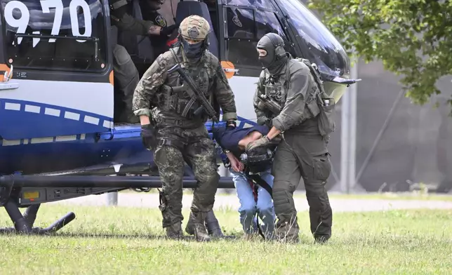 The alleged perpetrator of the knife attack in Solingen is escorted from a helicopter in Karlsruhe, Germany, Sunday, Aug. 25, 2024. (Uli Deck/dpa via AP)