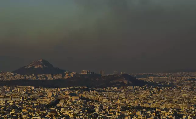 A general view of Athens with the Acropolis hill is seen as fire burns the northern part of the city on Monday, Aug. 12, 2024, Hundreds of firefighters are tackling a major wildfire raging out of control on the fringes of the Greek capital. (AP Photo/Petros Giannakouris)