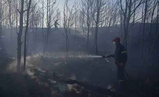 Firefighters operate near Penteli, northeast of Athens, Greece, Monday, Aug. 12, 2024. Hundreds of firefighters backed by dozens of water-dropping planes and helicopters were battling the flames from first light Monday.(AP Photo/Michael Varaklas)