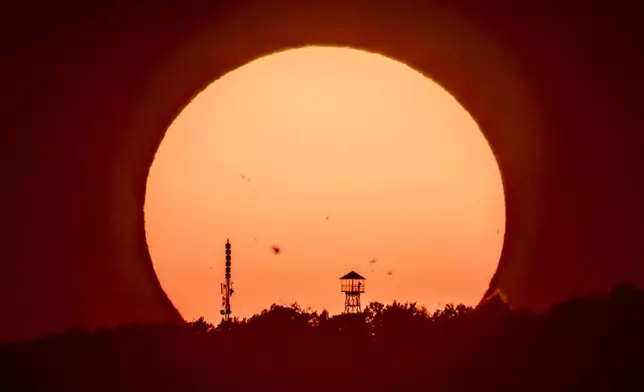 The setting sun glows behind Mount Karancs near Salgotarjan, northern Hungary, Sunday, Aug. 25, 2024. (Peter Komka/MTI via AP)