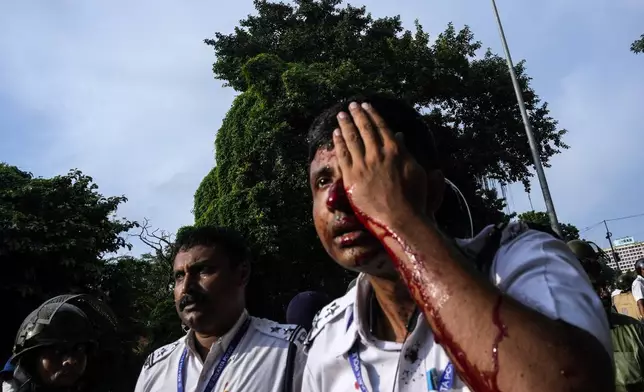 A bloodied policeman after protestors against the rape and murder of a resident doctor at a government hospital earlier this month, threw stones in Kolkata, India, Tuesday, Aug. 27, 2024. (AP Photo/Bikas Das)