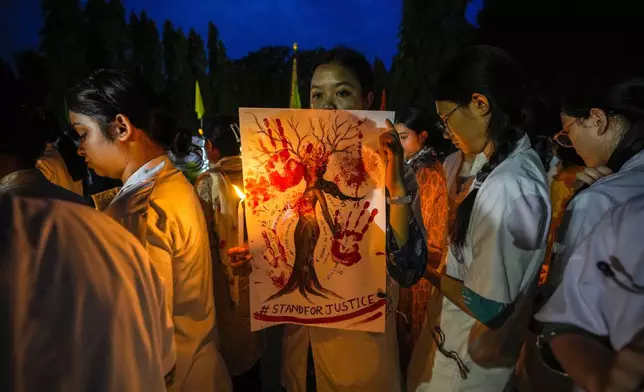 Veterinarian students hold candles and walk in a protest rally against the alleged rape and killing of a trainee doctor at a government hospital last week, in Guwahati, India, Saturday, Aug. 17, 2024. (AP Photo/Anupam Nath)