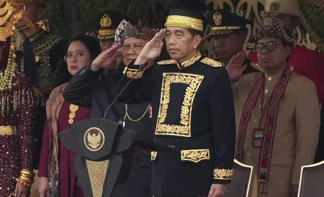 Indonesian President Joko Widodo, center, and Defense Minister and president-elect Prabowo Subianto, second left, salute during the ceremony marking Indonesia's 79th anniversary of independence at the new presidential palace in its future capital of Nusantara, a city still under construction on the island of Borneo, Saturday, Aug. 17, 2024. (AP Photo/Achmad Ibrahim)