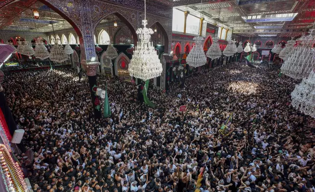 Shiite pilgrims mark the holiday of Arbaeen on Sunday, Aug. 25, 2024, in Karbala, Iraq. The holiday marks the end of the forty-day mourning period after the anniversary of the martyrdom of Imam Hussein, the Prophet Muhammad's grandson, in the 7th century. (AP Photo/Anmar Khalil)