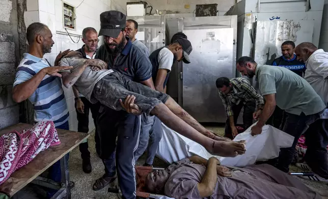 Palestinians mourn relatives killed in the Israeli bombardment of the Gaza Strip, at a hospital in Deir al-Balah, Tuesday, Aug. 27, 2024. (AP Photo/Abdel Kareem Hana)