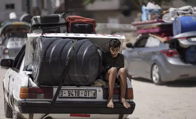 A Palestinian child rides in the trunk of a car as he evacuates Maghazi refugee camp in the central Gaza Strip, as part of a mass evacuation ordered by the Israeli military ahead of an operation, Saturday, Aug. 17, 2024. (AP Photo/Abdel Kareem Hana)