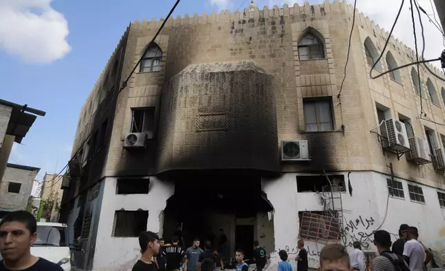 Palestinians stand outside a heavily damaged mosque following an Israeli military operation in the West Bank refugee camp of Al-Faraa, Thursday, Aug. 29, 2024. (AP Photo/Nasser Nasser)