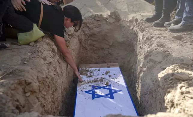 Rimon Buchshtab mourns during the funeral of her husband Yagev Buchshtab at a cemetery of the Kibbutz Nirim, southern Israel, Wednesday, Aug. 21, 2024. Buchshtab's body was one of six bodies of hostages, taken in Hamas' Oct. 7 attack, recovered by Israel's military during an operation in the Gaza Strip. (AP Photo/Leo Correa)