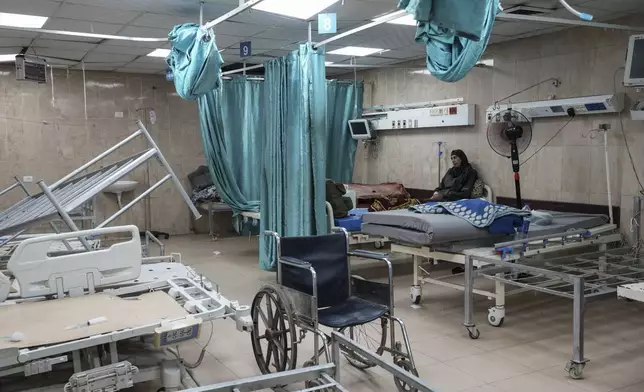 A woman sits on a bed in a room of the Al-Aqsa Martyrs hospital in Deir al Balah, Gaza Strip, Sunday, Aug. 25, 2024. (AP Photo/Abdel Kareem Hana)