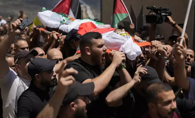 Mourners carry the body of Palestinian Rasheed Mahmoud Sadah, 23, who was killed during a rampage by Israeli settlers, during his funeral in the West Bank village of Jit, near Nablus, Friday, Aug. 16, 2024. (AP Photo/Nasser Nasser)