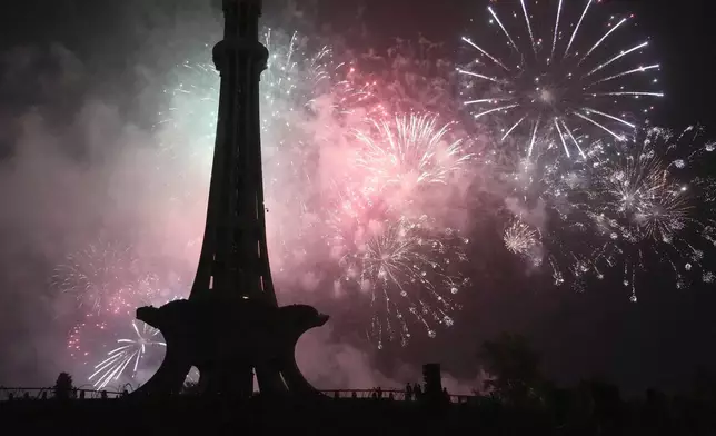 Fireworks light the sky close to the Minar-e-Pakistan or Pakistan monument during the Pakistan Independence Day celebrations, in Lahore, Pakistan, Wednesday, Aug. 14, 2024. (AP Photo/K.M. Chaudary)