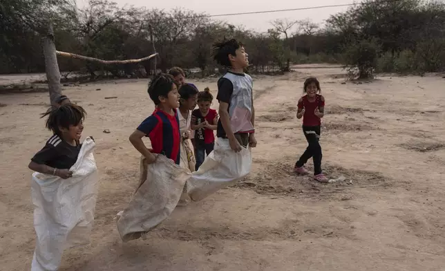 Manjui Indigenous children compete in a sack race in the Abisai community in Mariscal Estigarribia, in the western region of Paraguay known as the Paraguayan Chaco, Wednesday, Aug. 28, 2024. (AP Photo/Rodrigo Abd)