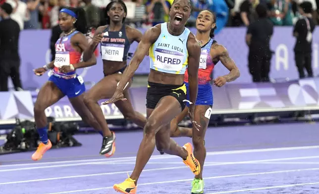 Julien Alfred, of Saint Lucia, celebrates after winning the women's 100-meters final at the 2024 Summer Olympics, Saturday, Aug. 3, 2024, in Saint-Denis, France. (AP Photo/Matthias Schrader)