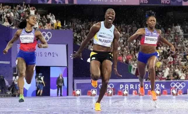 Julien Alfred, of Saint Lucia, celebrates after winning the women's 100-meter final at the 2024 Summer Olympics, Saturday, Aug. 3, 2024, in Saint-Denis, France. (AP Photo/David J. Phillip)