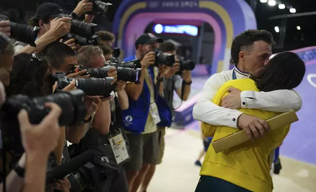 Romain Mahieu of France, winner of the bronze medal in the men's race, hugs women's gold medallist Saya Sakakibara of Australia, following the BMX racing events, at the 2024 Summer Olympics, Friday, Aug. 2, 2024, in Saint-Quentin-en-Yvelines, France. (AP Photo/Thibault Camus)