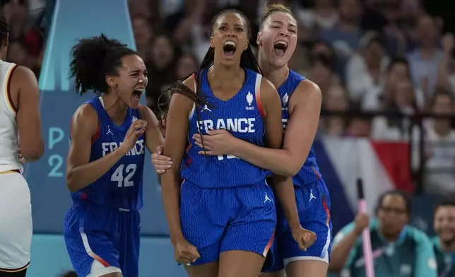 Leila Lacan (42), Iliana Rupert, center, and Alexia Chery (6), of France, celebrate during a women's quarterfinal game against Germany at Bercy Arena at the 2024 Summer Olympics, Wednesday, Aug. 7, 2024, in Paris, France. (AP Photo/Mark J. Terrill)