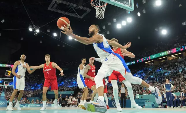 Rudy Gobert (27), of France drives past Germany during a men's semifinals basketball game at Bercy Arena at the 2024 Summer Olympics, Thursday, Aug. 8, 2024, in Paris, France. (AP Photo/Mark J. Terrill)