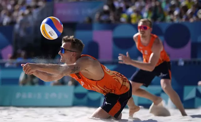 Netherland's Yorick de Groot goes low to make the save in a quarterfinal beach volleyball match against Germany at the 2024 Summer Olympics, Tuesday, Aug. 6, 2024, in Paris, France. (AP Photo/Robert F. Bukaty)