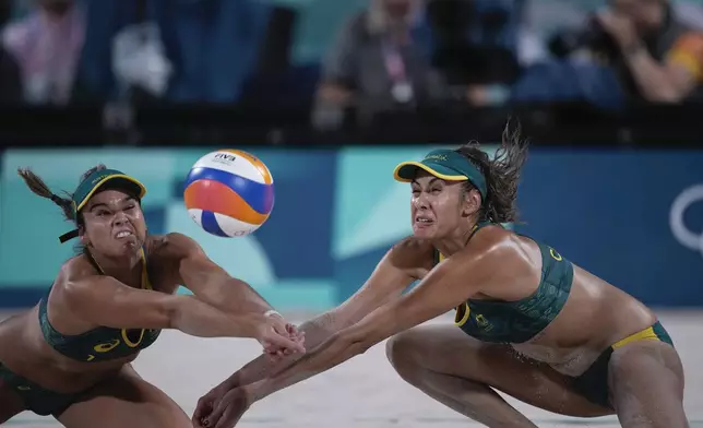 Australia's Mariafe Artacho del Solar, left, and Taliqua Clancy return a ball in the women's beach volleyball bronze medal match between Australia and Switzerland, at the 2024 Summer Olympics, Friday, Aug. 9, 2024, in Paris, France. (AP Photo/Louise Delmotte)